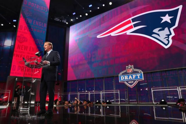 O comissário da NFL Roger Goodell anuncia uma escolha do New England Patriots durante a primeira rodada do Draft da NFL 2018 no AT&T Stadium em 26 de abril de 2018 em Arlington, Texas. 
