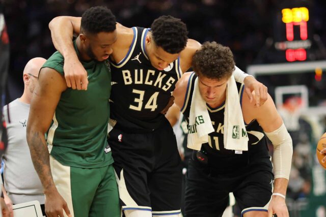 MILWAUKEE, WISCONSIN - 09 DE ABRIL: Giannis Antetokounmpo #34 do Milwaukee Bucks é ajudado fora da quadra por Thanasis Antetokounmpo #43 e Brook Lopez #11 após sofrer uma lesão durante o segundo tempo de um jogo contra o Boston Celtics no Fiserv Forum em abril 09 de setembro de 2024 em Milwaukee, Wisconsin.  NOTA AO USUÁRIO: O Usuário reconhece e concorda expressamente que, ao baixar e/ou usar esta fotografia, o Usuário está concordando com os termos e condições do Contrato de Licença da Getty Images.