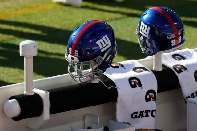 Os capacetes de BJ Hill #95 e Austin Johnson #98 do New York Giants, sentam-se no banco antes do início do jogo Giants e Baltimore Ravens no M&T Bank Stadium em 27 de dezembro de 2020 em Baltimore, Maryland.