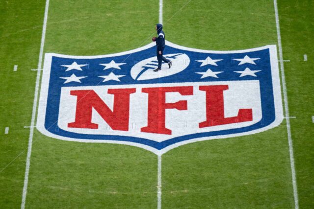Um jogador se aquece próximo ao logotipo da NFL pintado em campo antes da partida da NFL entre Seattle Seahawks e Tampa Bay Buccaneers na Allianz Arena em 13 de novembro de 2022 em Munique, Alemanha.