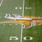 Uma visão geral do logotipo do Minnesota Vikings na linha de 50 jardas durante o jogo entre o Minnesota Vikings e o New Orleans Saints em 18 de dezembro de 2011 no Mall of America Field no Hubert H. Humphrey Metrodome em Minneapolis, Minnesota.