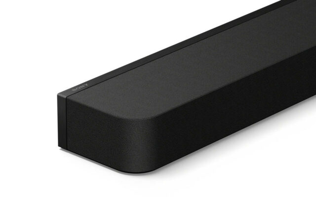 Um close do canto frontal de uma barra de som preta da Sony.