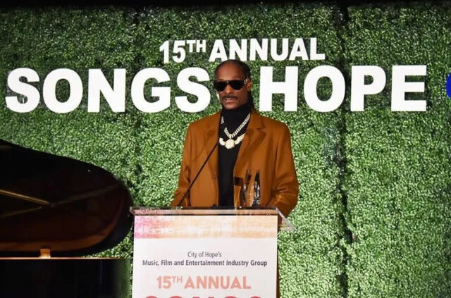 O rapper Snoop Dogg está em um pódio com o texto 