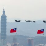 Helicópteros carregando bandeiras nacionais de Taiwan no céu acima de Taipei.  Taipei 101 está atrás deles.