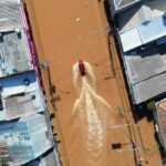 Uma visão das equipes de resgate dirigindo um barco nas águas da enchente no Brasil