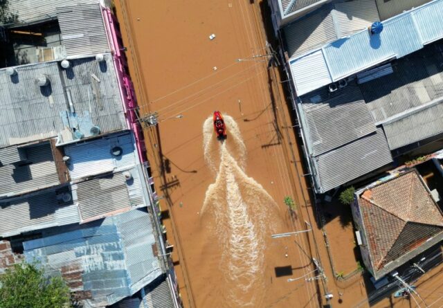 Uma visão das equipes de resgate dirigindo um barco nas águas da enchente no Brasil