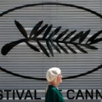 Uma mulher passa por um símbolo da Palma de Ouro na véspera da abertura do 77º Festival de Cinema de Cannes em Cannes, França, em 13 de maio de 2024. REUTERS/Stephane Mahe