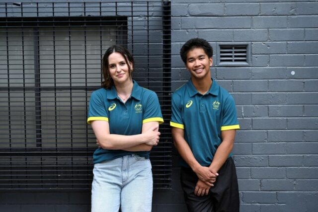 Atleta feminina (L) e atleta masculino encostados em uma parede para fotografia.