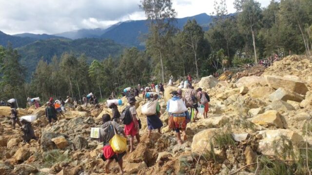 Moradores carregam suas malas após um deslizamento de terra mortal na província de Enga, em Papua Nova Guiné