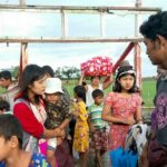 Um grupo de mulheres e crianças fugindo de sua aldeia em meio a novos combates entre as AA e os militares de Mianmar