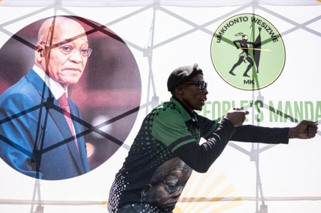 Um membro do pessoal de segurança do uMkhonto we Sizwe (MK) gesticula fora do Tribunal Superior de Joanesburgo antes do julgamento do Ministério Público privado, onde o ex-presidente sul-africano Jacob Zuma está processando o presidente sul-africano Cyril Ramaphosa por causa de um relatório médico vazado relacionado a um ataque de armas da década de 1990. julgamento por corrupção, em Joanesburgo, em 11 de abril de 2024. (Foto de EMMANUEL CROSET / AFP)