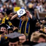 Um estudante usa um boné de formatura com a bandeira de Israel durante um protesto pró-palestino durante a cerimônia de formatura da Universidade de Michigan na primavera