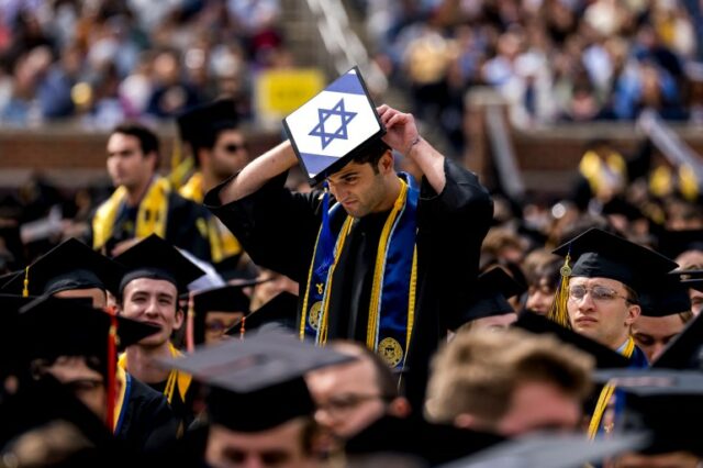 Um estudante usa um boné de formatura com a bandeira de Israel durante um protesto pró-palestino durante a cerimônia de formatura da Universidade de Michigan na primavera