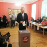 O presidente da Lituânia, Gitanas Nauseda, posa para os fotógrafos quando se prepara para votar durante o primeiro turno das eleições presidenciais da Lituânia, em uma seção eleitoral em Vilnius