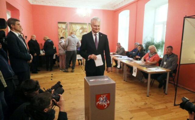 O presidente da Lituânia, Gitanas Nauseda, posa para os fotógrafos quando se prepara para votar durante o primeiro turno das eleições presidenciais da Lituânia, em uma seção eleitoral em Vilnius