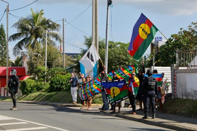 as pessoas seguram bandeiras coloridas em uma rua tropical