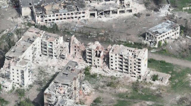 Uma foto de drone de Chasiv Yar mostra prédios de apartamentos destruídos e crateras de bombas.