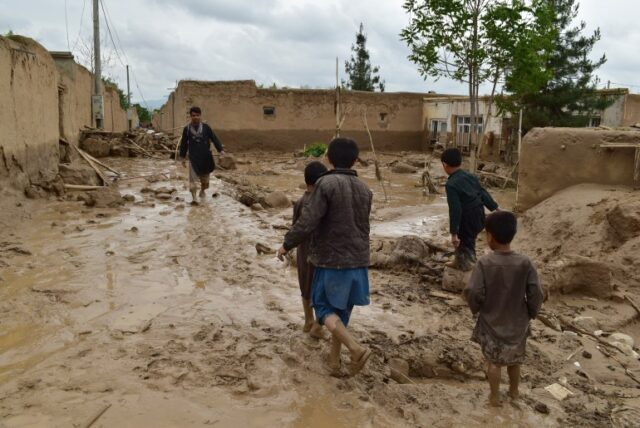 Pessoas caminham perto de suas casas danificadas após fortes enchentes na província de Baghlan, no norte do Afeganistão, no sábado, 11 de maio de 2024. Inundações repentinas causadas por chuvas sazonais na província de Baghlan, no norte do Afeganistão, mataram dezenas de pessoas na sexta-feira, disse um oficial do Taleban.  (Foto AP/Mehrab Ibrahimi)