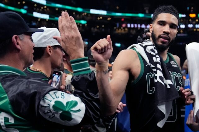 O atacante do Boston Celtics, Jayson Tatum, à direita, gesticula para um torcedor depois que o Celtics derrotou o Cleveland Cavaliers por 113-98 no jogo 5 de uma série de playoffs da segunda rodada de basquete da NBA na quarta-feira, 15 de maio de 2024, em Boston.  Os Celtics avançaram para as finais da Conferência Leste.  (Foto AP/Charles Krupa)