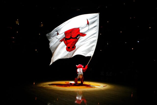 Benny the Bull, mascote do Chicago Bulls, agita uma bandeira gigante com o logotipo dos Bulls durante as festividades antes do jogo contra o New York Knicks no United Center em 9 de dezembro de 2008 em Chicago, Illinois.  NOTA AO USUÁRIO: O usuário reconhece e concorda expressamente que, ao baixar e/ou usar esta fotografia, o usuário concorda com os termos e condições do Contrato de Licença da Getty Images.