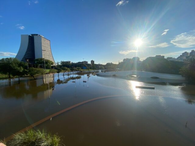 O sol brilha sobre a paisagem de uma cidade inundada em Porto Alegre, no Brasil.