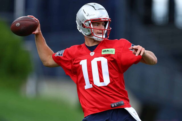 FOXBOROUGH, MASSACHUSETTS - 29 DE MAIO: Drake Maye # 10 do New England Patriots joga a bola durante o treino fora de temporada do New England Patriots OTA em 29 de maio de 2024 em Foxborough, Massachusetts.