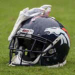O capacete e as luvas de Will Parks #34 do Denver Broncos · descansam em campo antes do jogo entre o Baltimore Ravens e o Denver Broncos no M&T Bank Stadium em 23 de setembro de 2018 em Baltimore, Maryland.