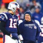 Tom Brady #12 conversa com o técnico Bill Belichick do New England Patriots antes de um jogo contra o Dallas Cowboys no Gillette Stadium em 24 de novembro de 2019 em Foxborough, Massachusetts.
