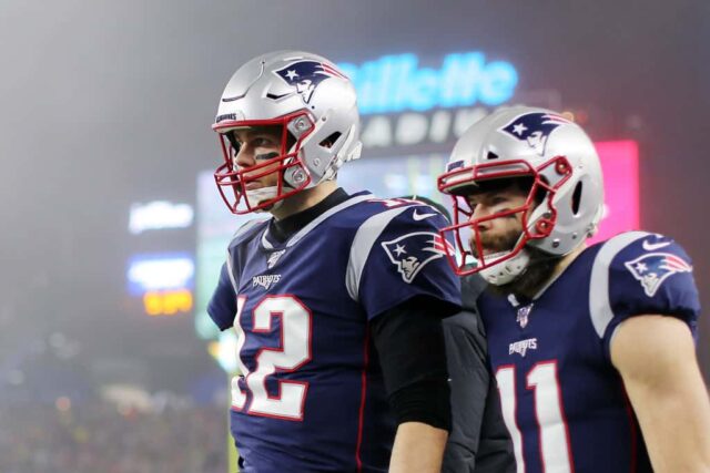 Tom Brady #12 do New England Patriots e Julian Edelman #11 observam depois que Edelman marcou um touchdown no segundo quarto do jogo AFC Wild Card Playoff no Gillette Stadium em 04 de janeiro de 2020 em Foxborough, Massachusetts. 