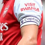 Um close de uma camisa do Arsenal com um anúncio do Visit Rwanda