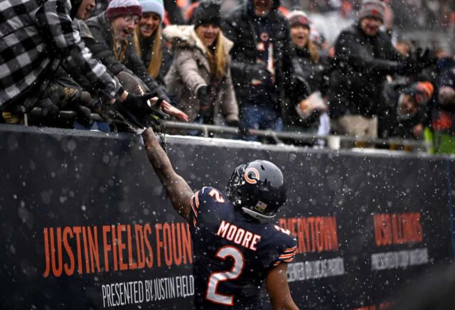 DJ Moore nº 2 do Chicago Bears dá uma bola de futebol a um torcedor após receber um touchdown durante o primeiro quarto contra o Atlanta Falcons no Soldier Field em 31 de dezembro de 2023 em Chicago, Illinois.