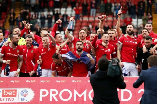 Os jogadores do Wrexham comemoram a vitória e a promoção à League One após a vitória da Sky Bet League Two sobre o Forest Green Rovers