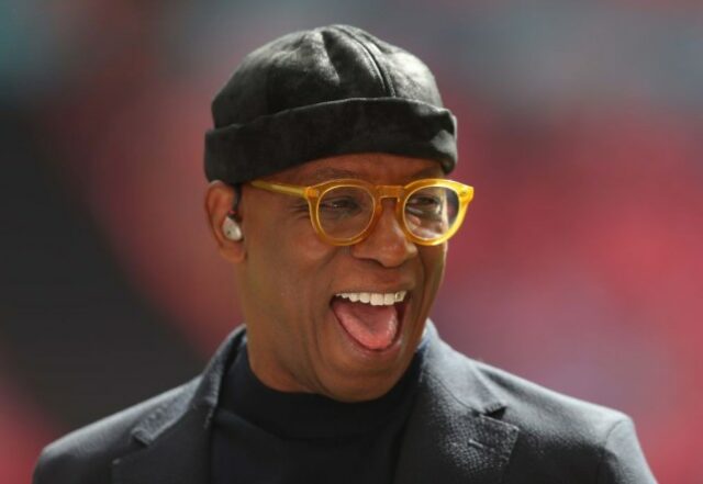 Ian Wright usando óculos de aro laranja.