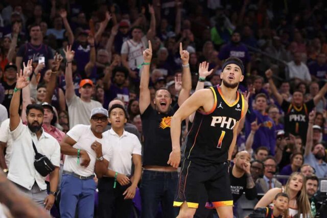 Devin Booker nº 1 do Phoenix Suns assiste a um arremesso de três pontos contra o Minnesota Timberwolves durante a segunda metade do quarto jogo dos playoffs da primeira rodada da Conferência Oeste no Footprint Center em 28 de abril de 2024 em Phoenix, Arizona.  Os Timberwolves derrotaram os Suns por 122-116 e venceram a série por 4-0.