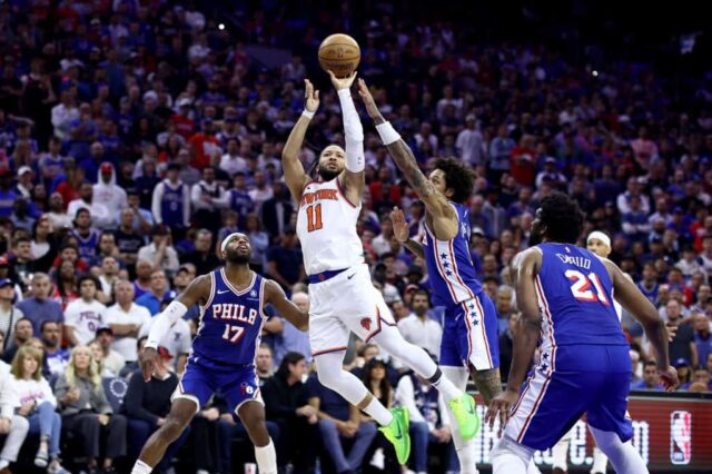 Jalen Brunson # 11 do New York Knicks atira sobre Kelly Oubre Jr. # 9 do Philadelphia 76ers durante o quarto quarto do jogo seis dos Playoffs da Primeira Rodada da Conferência Leste no Wells Fargo Center em 02 de maio de 2024 na Filadélfia, Pensilvânia. 