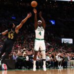 Jrue Holiday # 4 do Boston Celtics chuta a bola sobre Donovan Mitchell # 45 do Cleveland Cavaliers durante o terceiro quarto do segundo jogo dos playoffs da segunda rodada da Conferência Leste no TD Garden em 09 de maio de 2024 em Boston, Massachusetts.