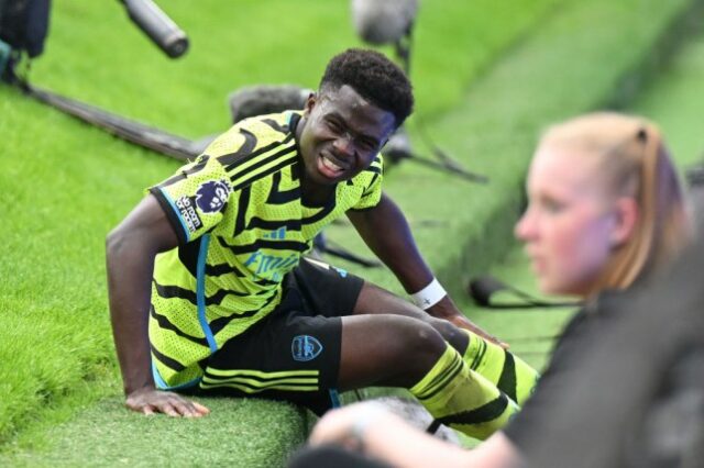 Bukayo Saka é fotografado com dor depois de cair desajeitadamente em uma encosta íngreme atrás de um dos gols durante a partida da Premier League entre Manchester United e Arsenal