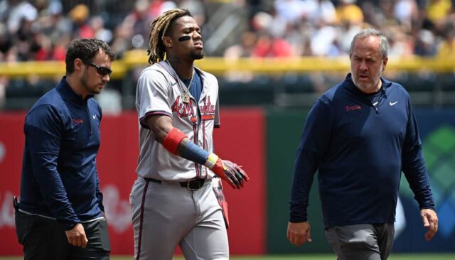 Ronald Acuña Jr., nº 13 do Atlanta Braves, sai de campo com os treinadores após uma aparente lesão no primeiro turno durante o jogo contra o Pittsburgh Pirates no PNC Park em 26 de maio de 2024 em Pittsburgh, Pensilvânia.