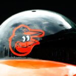 O logotipo do Baltimore Orioles é visto em um capacete de batedor durante o jogo entre o Boston Red Sox e o Baltimore Orioles no Fenway Park em 25 de junho de 2015 em Boston, Massachusetts.