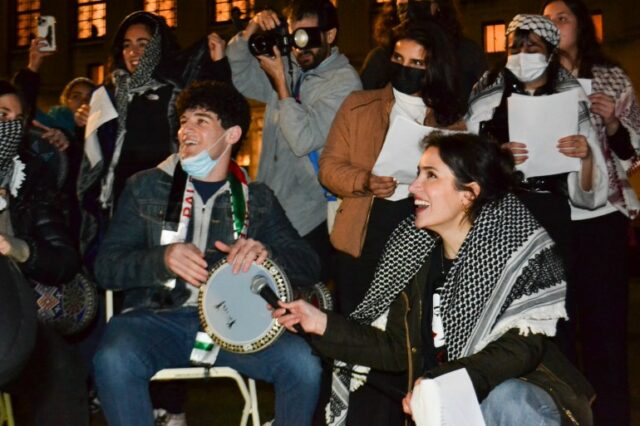 Estudantes manifestantes tocando música no acampamento da Universidade Columbia, em Nova York (Yasmeen Altaji/Al Jazeera)