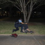 Um oficial aborda um manifestante pró-Palestina durante uma tentativa de acampamento fora do campus no centro da cidade de Nova Orleans