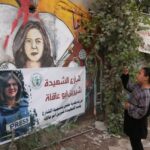 Uma menina palestina tira fotos no local onde a repórter da Al Jazeera Shireen Abu Akleh foi morta a tiros durante um ataque israelense, em Jenin, na Cisjordânia ocupada por Israel, em 3 de julho de 2022.