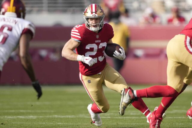 Christian McCaffrey #23 do San Francisco 49ers carrega a bola contra o Washington Commanders durante o primeiro tempo do jogo no Levi's Stadium em 24 de dezembro de 2022 em Santa Clara, Califórnia.