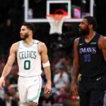 Kyrie Irving nº 11 do Dallas Mavericks e Jayson Tatum nº 0 do Boston Celtics assistem durante o segundo quarto do primeiro jogo das finais da NBA de 2024 no TD Garden em 06 de junho de 2024 em Boston, Massachusetts.