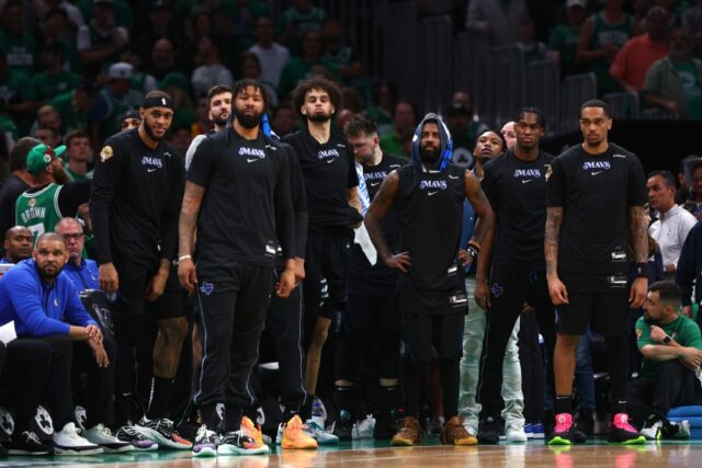     Kyrie Irving # 11 do Dallas Mavericks e companheiros de equipe assistem durante o quarto período contra o Boston Celtics no primeiro jogo das finais da NBA de 2024 no TD Garden em 06 de junho de 2024 em Boston, Massachusetts.