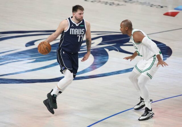 DALLAS, TEXAS - 12 DE JUNHO: Luka Dončić nº 77 do Dallas Mavericks dribla a bola enquanto é defendido por Al Horford nº 42 do Boston Celtics no quarto período do terceiro jogo das finais da NBA de 2024 no American Airlines Center em 12 de junho, 2024 em Dallas, Texas.  NOTA AO USUÁRIO: O Usuário reconhece e concorda expressamente que, ao baixar e/ou usar esta fotografia, o Usuário está concordando com os termos e condições do Contrato de Licença da Getty Images.