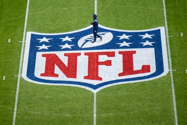 Um jogador se aquece próximo ao logotipo da NFL pintado em campo antes da partida da NFL entre Seattle Seahawks e Tampa Bay Buccaneers na Allianz Arena em 13 de novembro de 2022 em Munique, Alemanha.