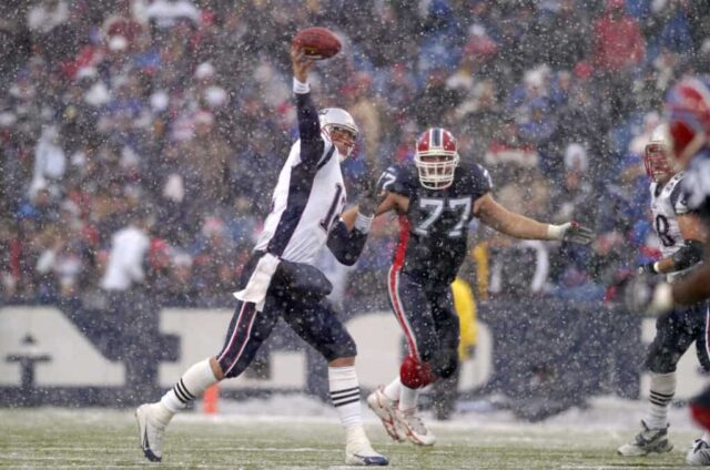 O quarterback do New England Patriots, Tom Brady, faz um passe em condições de neve durante um jogo contra o Buffalo Bills no Ralph Wilson Stadium em Orchard Park, Nova York, em 11 de dezembro de 2005. O New England venceu o jogo por 35-7. 