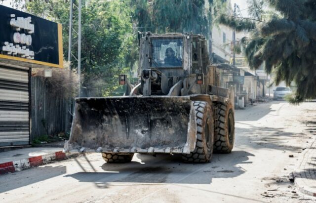 Uma escavadeira do exército israelense manobra em uma estrada durante um ataque em Jenin
