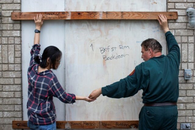 Shan Mei Martinez e Mario Martinez fixam suportes de porta para proteger a porta traseira voltada para a baía, enquanto os residentes se preparam para a chegada do furacão Beryl em Port Lavaca, Texas, EUA, 7 de julho de 2024. REUTERS/Kaylee Greenlee Beal